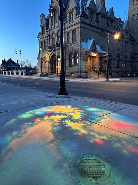 An image of colourful  lights on a side walk in front of Carleton Place Town Hall